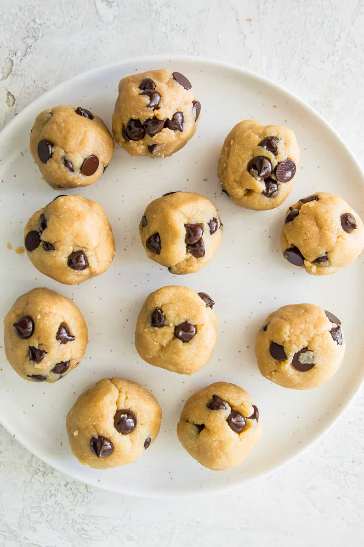 A plate with no bake chocolate chip cookie dough bites on it.