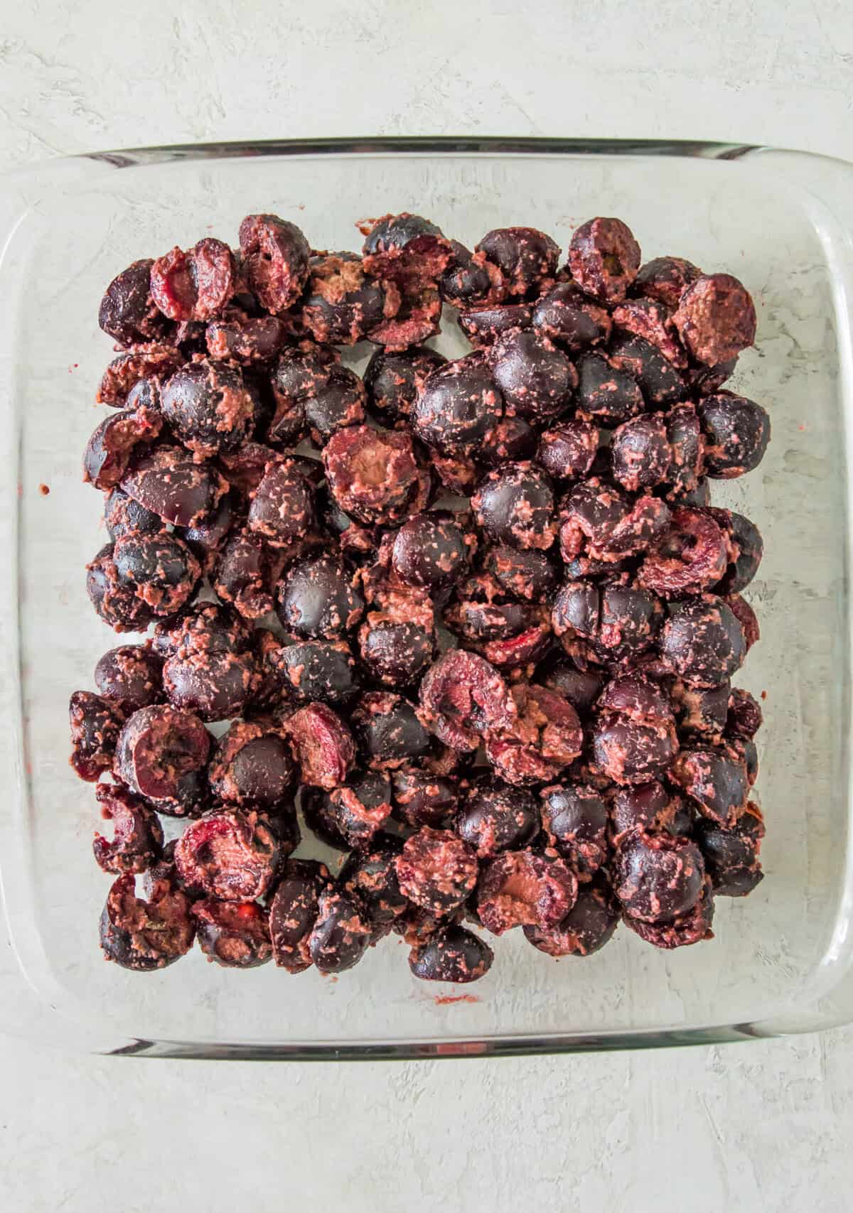 A glass baking dish filled with chopped cherries.