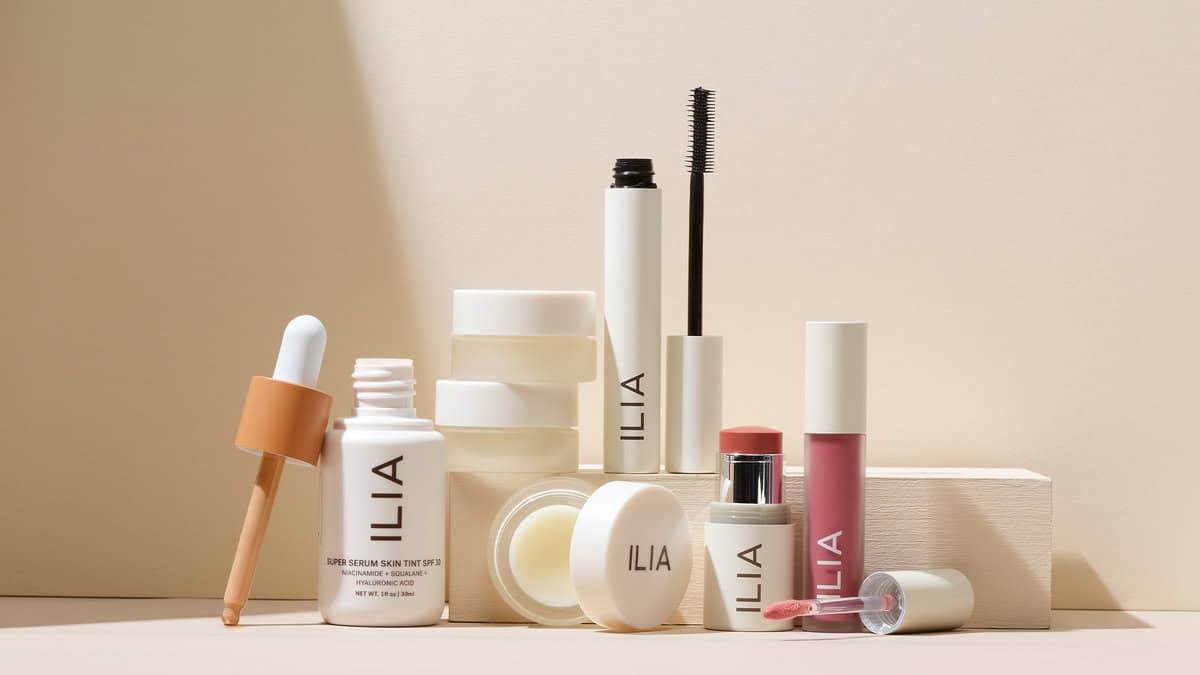 A bunch of different Ilia brand makeup products lined up next to each other and stacked on top of each other.