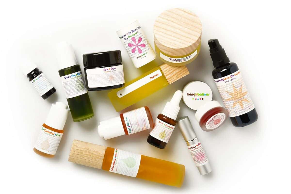 A collection of Living Libations skincare products in various sized glass containers and vials.