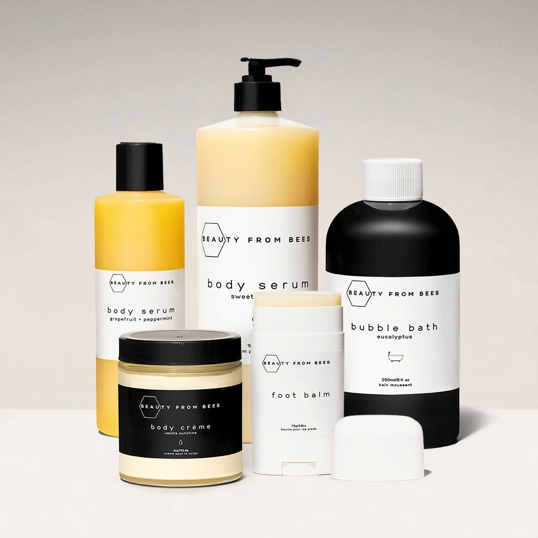 Five bottles of Beauty from Bees skincare products including bubble bath, body serum and body cream.